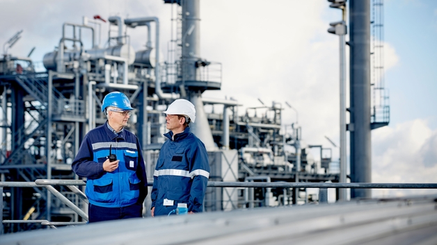 Especialistas técnicos em frente a uma refinaria