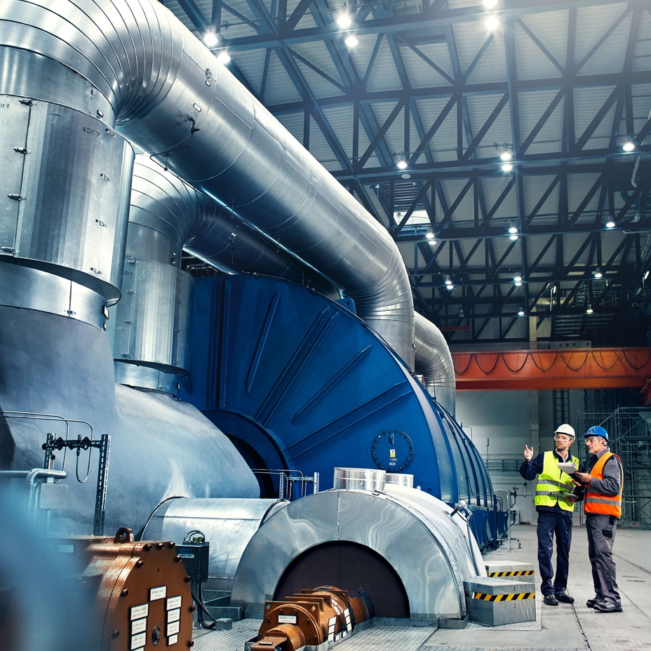 Imagem de um engenheiro em frente a uma turbina na fabrica de energia