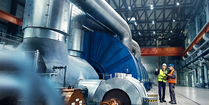 Imagem de um engenheiro em frente a uma turbina na fabrica de energia