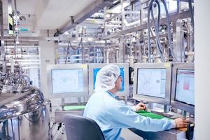 Funcionário de empresa farmacêutica monitora dados de fabricação em tempo real