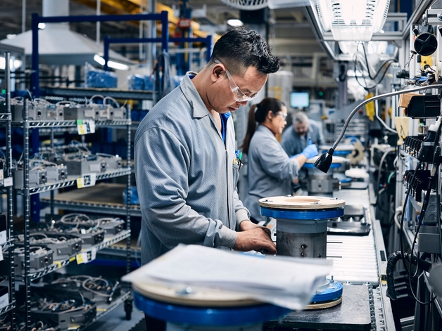 Trabalhador da produção montando um medidor.